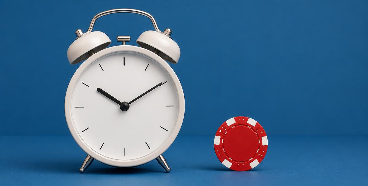 An alarm clock and a single casino chip on a blue background